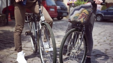 Två personer cyklar i hållbar stadkärna